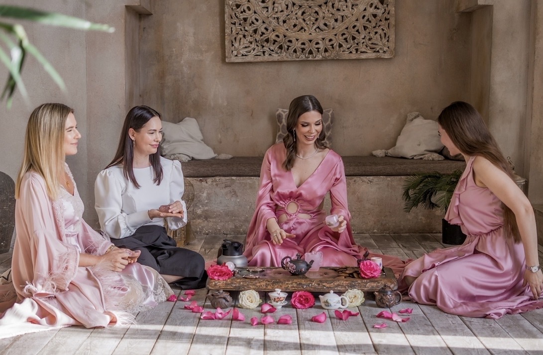 Malena leading a tea ceremony with three women in a serene setting